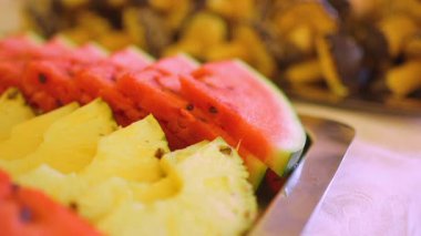 Rengarenk bir meyve ve ananas seçimi servis tabağına güzelce yerleştirilmiş, yaz toplantısı veya düğün resepsiyonu için mükemmel..