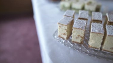 Taze pişmiş, hafif şekerle tozlanmış bir cheesecake. Kutlama sırasında tatlı masasında sunulur. Misafirlere servis edilmeye hazır..