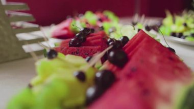 Tatlı ve sulu bir meyve aperatifi için taze karpuz dilimleri ve kirazların birleşimi..