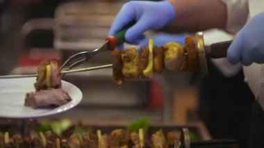 Bir şef taze pişmiş eti bir tabağa koyar, profesyonel bir mutfakta gurme yemeği hazırlar..