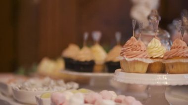Süslü bir masada zarif bir kutlama için servis edilen kremalı kekler..