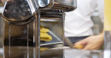 Bir şef profesyonel mutfak ortamında İtalyan makarnası yapar..