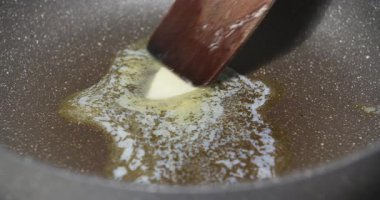 Eriyen tereyağının zengin dokusunu gösteren sıkı bir yakın çekim, yemek ve pişirmede birçok tarifin anahtarı..