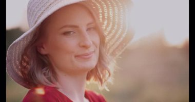 Gün batımında arkasında gökyüzünü boyayan bir kadın huzur ve uyum içinde duruyor..