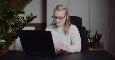 Ortak ofis çalışma ortamında bilgisayar üzerinde çalışan serbest çalışan bir kadın..