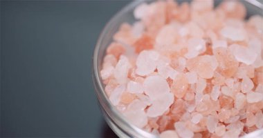 Kaba Himalaya pembe tuz kristalleri kırsal bir mutfak ortamında mutfak masasına saçılmış..