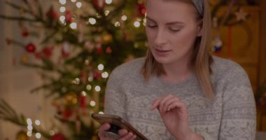 Bir kadın Noel sezonu boyunca tabletinden online alışveriş yapar.