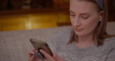 Sosyal medyayı taramak için akıllı telefonunu kullanan bir kadının yakın plan fotoğrafı.