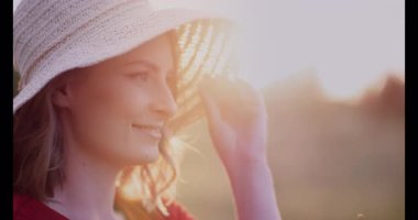 Genç bir kadın günbatımının altın ışığına dalmış, huzur ve merak içinde duruyor..