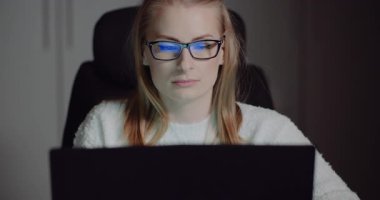 İş kadını parlak ofisteki dizüstü bilgisayarında birden fazla dijital projeyi yönetiyor.