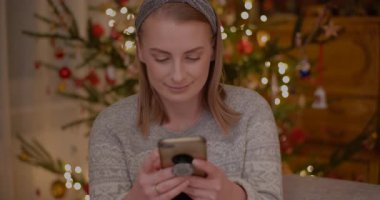 Mutlu bir kadın Noel tatilinde arkadaşlarına telefonundan mesaj atar.