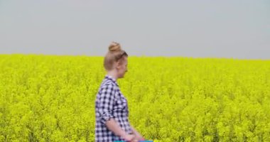 Kırsal bir arazide çiçek açan kolza tohumu tarlası manzarası. Doğa, tarım ve mevsimsel mahsul büyümesi kavramı.