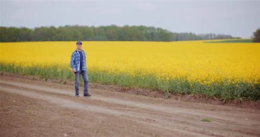 Çiftçi bitki sağlığı, büyüme süreci ve toprak durumunu değerlendirmek için tarlada yürüyor