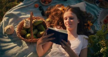 Bir çocuk sıcak güneş ışığı altında huzurlu bir yaz transında çimenlerin üzerinde yatıyor.