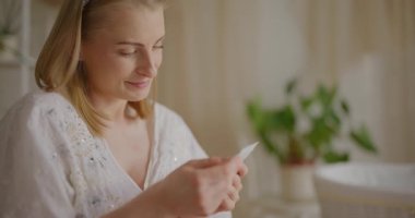 Neşeli bir hamile kadının portresi. Kalbine yakın bir ultrason fotoğrafı tutuyor. Bebeğinin doğumunu sabırsızlıkla bekliyor..