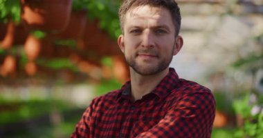 Seradaki mutlu genç bir çiftçinin portresi başarılı bir şekilde bahçe işleriyle uğraşıyor..