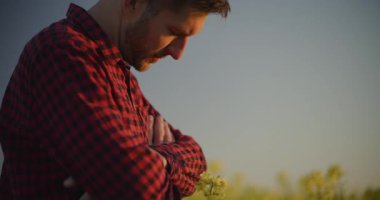 Kederli çiftçi tarlaya derin derin bakıyor, tarımdaki zorlukları yansıtıyor..