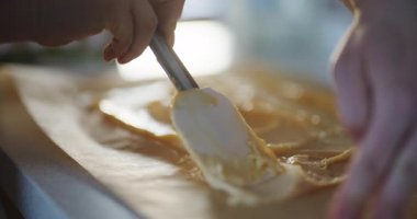 Parşömen kağıdına serpilmiş hamurun yakın plan çekimi, choux hamur işlerinin hazırlanmasını gösteriyor..