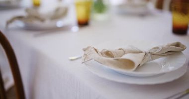 Paskalya için güzel dekore edilmiş bir masa. Tabaklar, peçeteler ve kutlamaya hazır bardaklar..