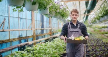 Gururlu bir çiftçi, yeni hasat edilmiş, sağlıklı sebzelerle tarlasında duruyor, çalışmalarının meyvelerini sergiliyor..