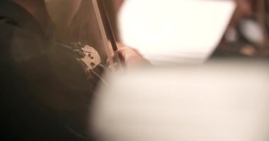 Odaklanmış bir adam evde müzik okurken ustalıkla keman çalıyor..