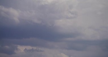 Gökyüzünde süzülen tüylü kümülüs bulutlarının dinamik zaman dilimi.