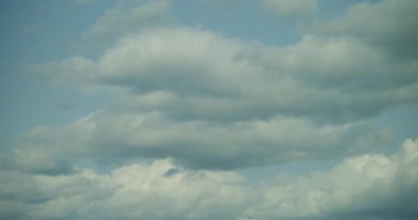 Mavi gökyüzünde oluşan ve hareket eden kümülüs bulutlarının dramatik zamanlaması doğanın ve atmosferik değişimlerin dingin güzelliğini yakalıyor..