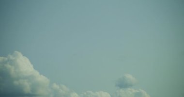 Geniş bir zaman atlamalı bulut görüntüsü zarif bir şekilde canlı mavi gökyüzünde hareket ediyor, bu da güzel havayı gösteriyor..