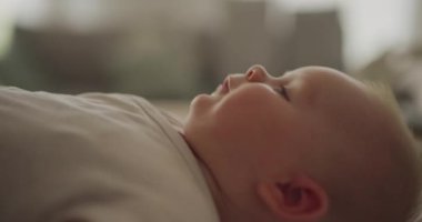 Üstünü değiştirirken sıcak bir şekilde gülümseyen sevimli bir erkek bebek. Erken çocukluğun masumiyetini ve neşesini yakalar..