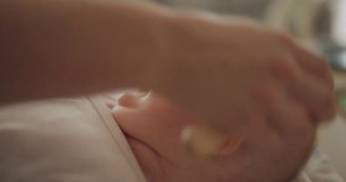 Yeni doğmuş bir çocuğun banyodan sonra saçlarını annesi tarıyor ve hassas anları yakalıyor..