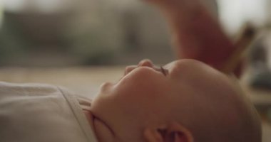 Neşeli bir çocuk, annesi saçlarını tarıyor, kafa ve cilt bakımına odaklanıyor..