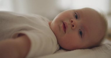 Doğrudan kameraya bakan sevimli, gülümseyen bir çocuğun yakın çekimi. Masum ve neşeli ifadeyi yakalar.