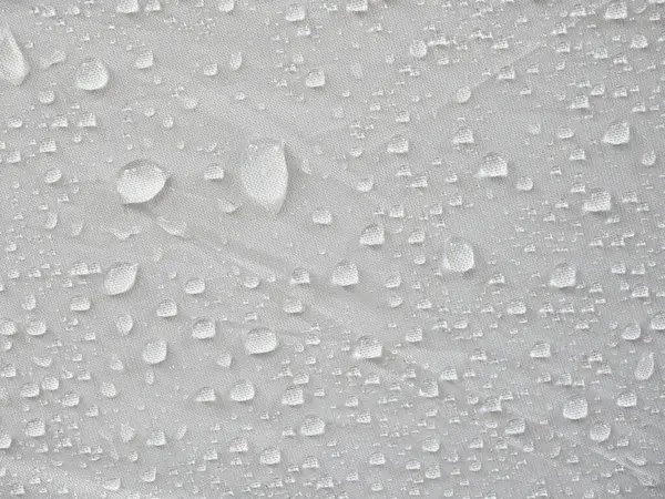Water droplets on white textile, Moist rain drops on the surface of the umbrella