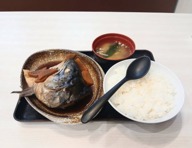 Soya soslu soya balığı kafası. Beyaz bir konteynırda malzemeyle buğulanmış. Japon yemeği ve pilav.