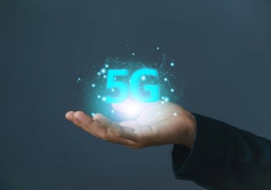 İş adamı, hologram 5G dijital teknoloji gösteriyor, dünyadaki bilgilere erişim sağlıyor. 5G kablosuz internet ağı kavramı veya IOT, yüksek hızlı iletişim bağlantısı.