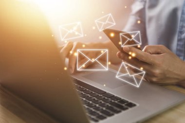İş adamı akıllı telefondan ya da bilgisayardan mektup yolluyor. Elektronik posta kavramı, dijital teknolojide bilgi almak ve göndermek için internet ağındaki çevrimiçi iletişimdir.