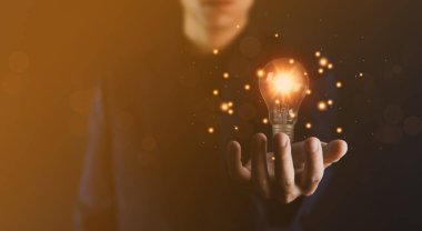 İş adamı elinde bir ampul grafik dijital teknoloji soyutlaması tutuyor. Yaratıcı ve yenilikçi bir fikir hayal et. İş dünyasındaki beyin fırtınasından beyin fırtınasına. Geliştirme, büyüme ve başarı stratejileri