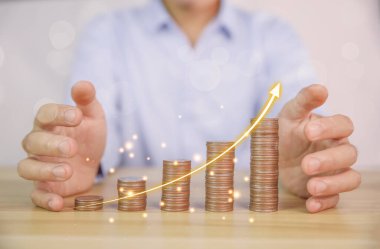 İşadamı hisse senedi finansal endekslerini analiz eder ve hesaplar. Bozuk para istiflemek büyüyor. Banka hesabında para biriktirme ve iş yatırımlarından elde edilen karı maksimuma çıkarmak için fonlara yatırım yapma fikirleri