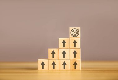 Tahta blok düzenleme kariyer yolunda bir basamak. Masanın üzerinde bir ok gibi bir grafikle. İşletme başarısı süreci borsa eğilimi artıyor. Boşluğu kopyala