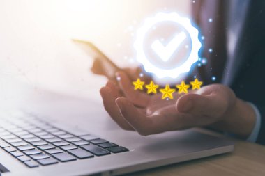 İşadamı, dijital teknoloji simgesini işaretli gösteren bir dizüstü bilgisayar kullanıyor. En iyi kalite güvence hizmeti konsepti, ürün performans güvencesi ve sektör lideri ISO sertifikası.