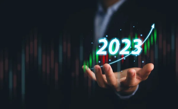 businessman plots a powerful analytical strategy that shows a positive digital technology chart. Stock growth development ideas, investment, stock market, economy, and business success goals in 2023.
