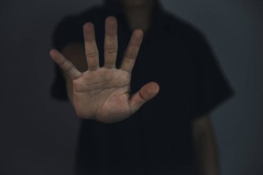 Erkek eli, dur işareti gösteriyor. Şiddeti durdur kavramı. Uyarı, yasaklama, inkar. Koyu arkaplanda.