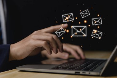 İş adamı bilgisayardan mektup gönderiyor. Elektronik posta kavramı, dijital teknolojide bilgi almak ve göndermek için internet ağındaki çevrimiçi iletişimdir.