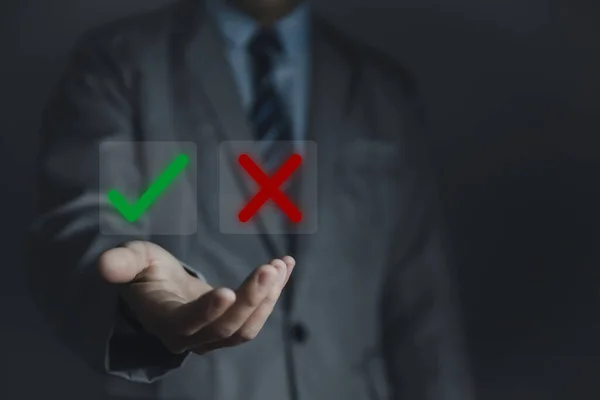 Businessman hand showing right and wrong symbol The idea is to decide to vote. Think yes or no decisions, and business options for difficult situations. true and false symbols agreeing