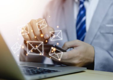 İş adamı bilgisayardan mektup gönderiyor. Elektronik posta kavramı, dijital teknolojide bilgi almak ve göndermek için internet ağındaki çevrimiçi iletişimdir.