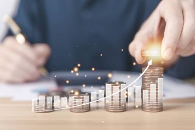 Businessman putting coins and charts. Financial concept of bank account savings and investments to maximize profits. business investments for future growth and success