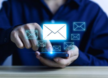 İş adamı akıllı telefondan mektup yolluyor. Elektronik posta kavramı, dijital teknolojide bilgi almak ve göndermek için internet ağındaki çevrimiçi iletişimdir.