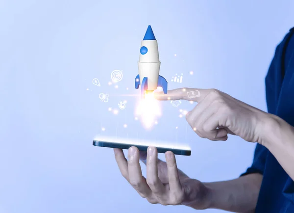 Businessman using smartphone showing rocket and icon Startup business concept Entrepreneurship concept and online digital business network connection on the interface Online Marketing, Technology and