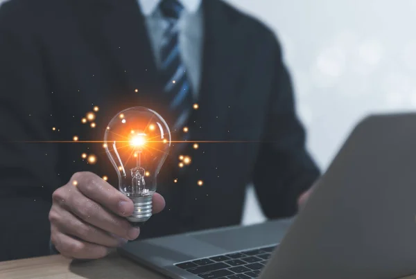 businessman holding a light bulb Digital technology. imagine an idea Creative and innovative. brain to brainstorm ideas in business. Strategies for development, growth, and success