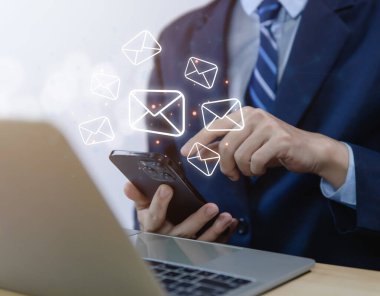 İş adamı bilgisayardan mektup gönderiyor. Elektronik posta kavramı, dijital teknolojide bilgi almak ve göndermek için internet ağındaki çevrimiçi iletişimdir.